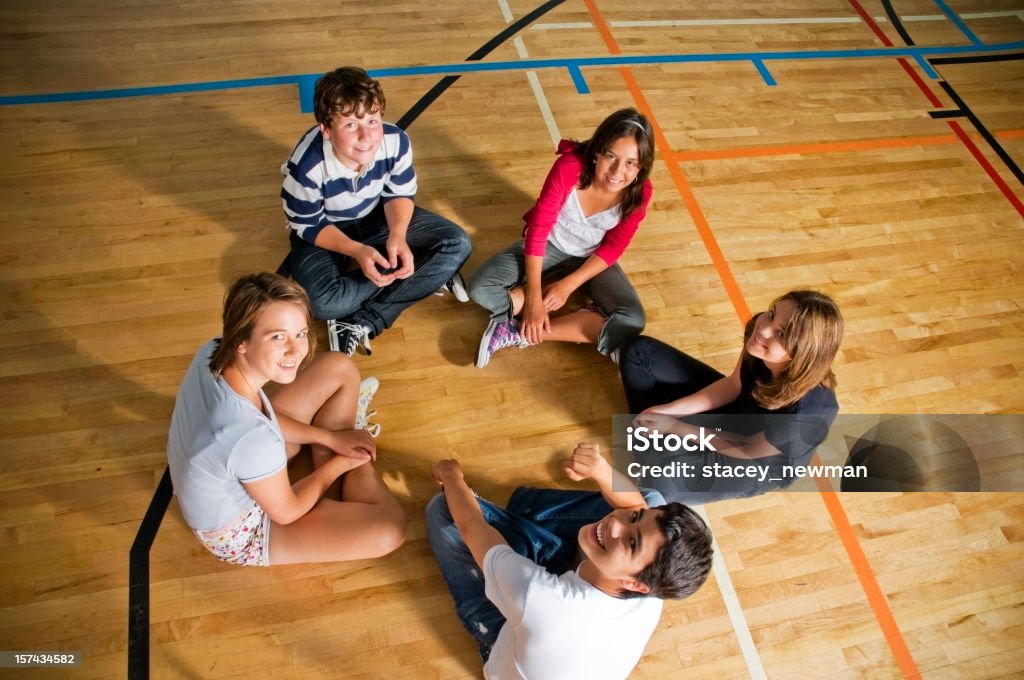 Felices estudiantes en un círculo, gimnasio escolar - Foto de stock de Adolescencia libre de derechos