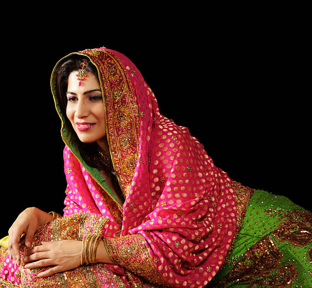 istock Young Indian woman in lehenga smiling contently (isolated on black) 157435005