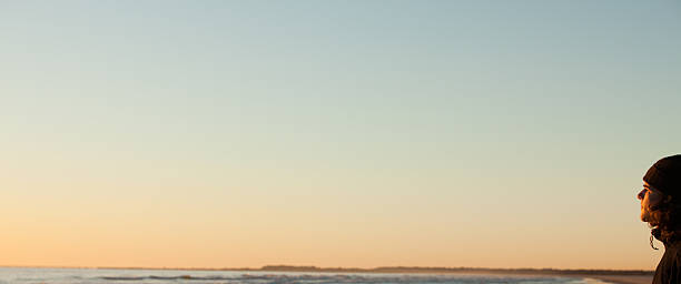 istock Young man watching the sunrise at waters edge 157435237