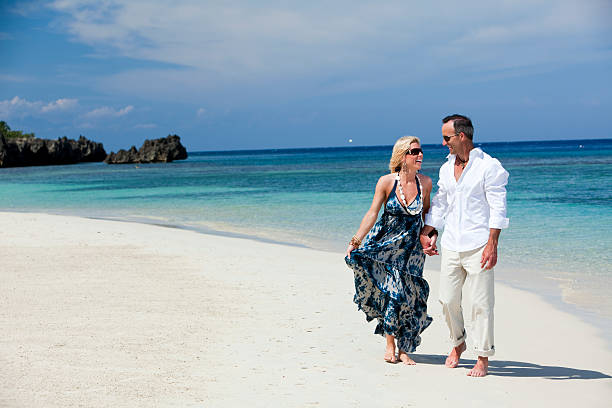 Happy mature couple conversing on beach stock photo