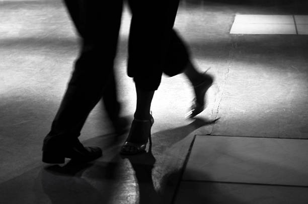 Action shot of the feet of a man and woman dancing Couple tangoing in a ballroom. Captured in black and white with motion blur. tango dance stock pictures, royalty-free photos & images