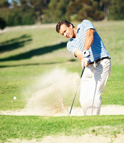 istock Mature golf player hitting out of a sand trap 157435553