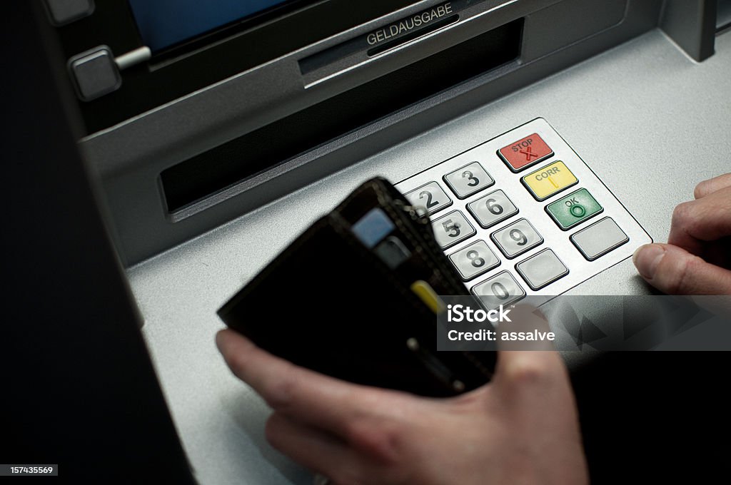 tiping the code on a cash dispenser ATM  ATM Stock Photo