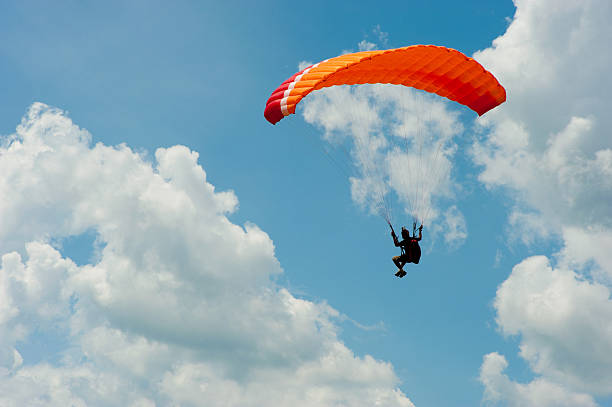 полеты на параплане в голубого неба - extreme sports risk high up sport стоковые фото и изображения