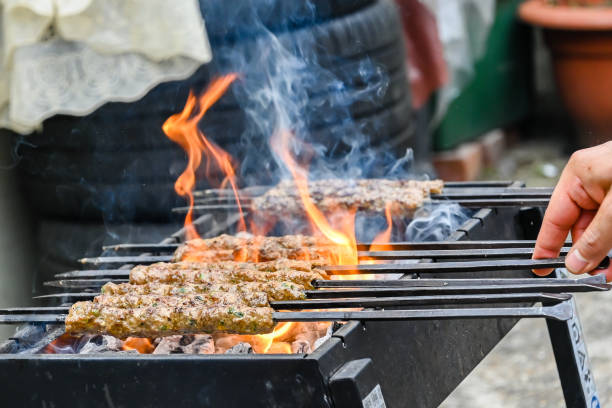 London, UK, 24 June  2023: Spicy Seekh Kebabs on skewers on the grill in the garden