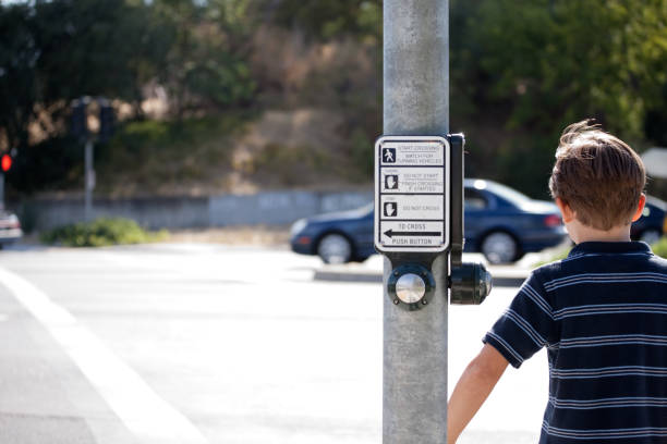 Young child waiting to cross the street.