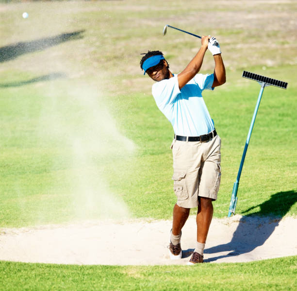 Motion blur golfer swinging driver club on teeing ground sending golf ball to fairway