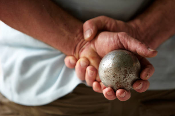 istock Senior man with hands behind his back holding a metal ball 157437169
