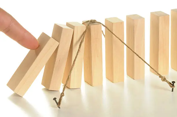 Photo of Illustration using tethered wooden dominos for insurance