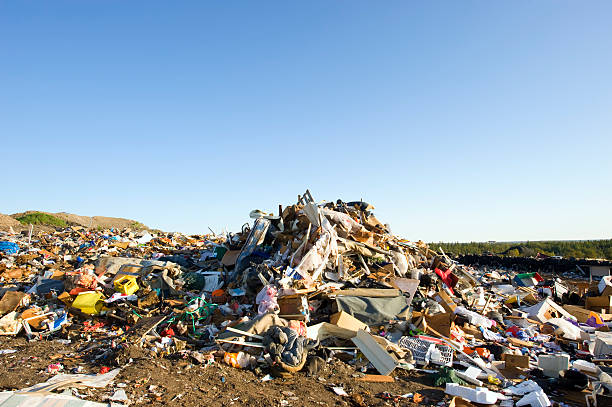 Large pile of garbage at a landfill with blue sky. stock photo