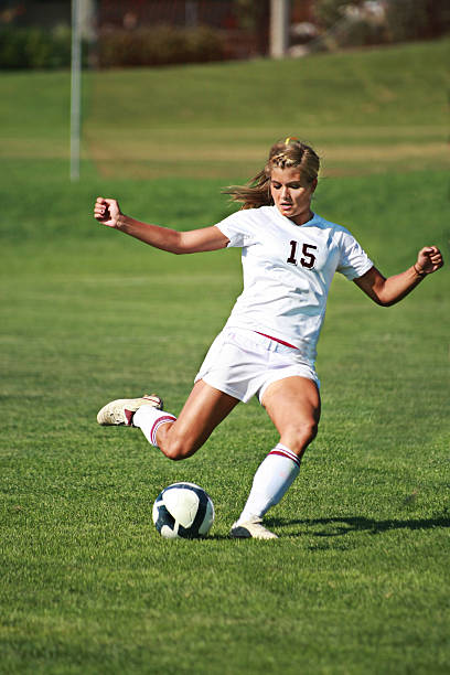 Female Soccer Player in White Power Kicks with copyspace stock photo
