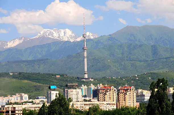 A view of Kok Tobe communication tower in Almaty, Kazakhstan with beautiful mountain range in the background.