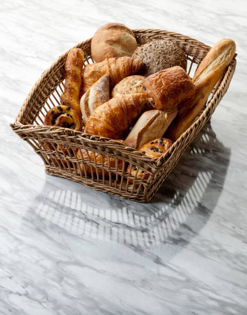 A basket full of delicious freshly baked bread on wooden background