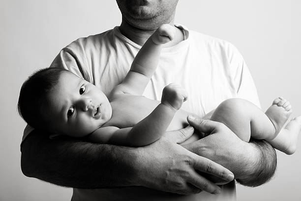 istock Man holding baby in arms 157437768