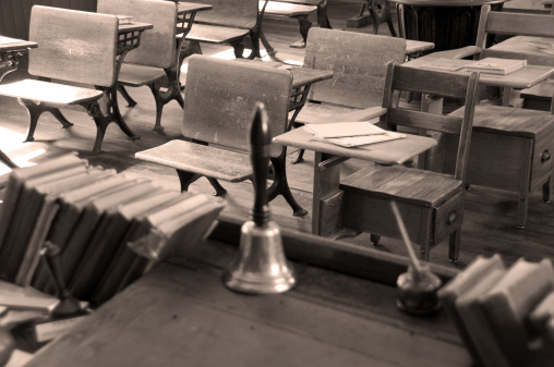 Old classroom student desks and a teacher's desk in an old rural one room schoolhouse... Sepia