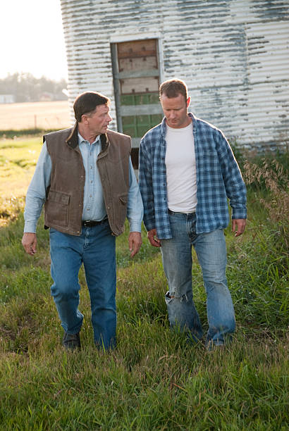 istock Two farmers walking away from a white barn 157438179