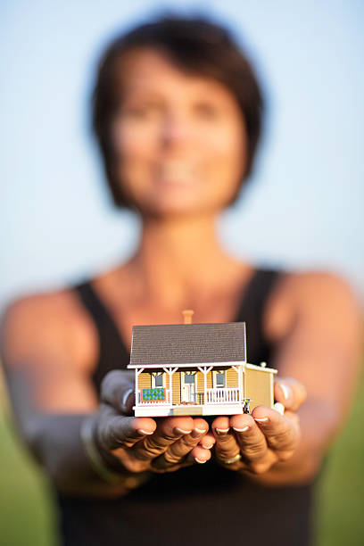istock Female holding house 157438420