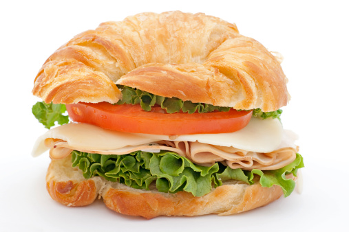 croissant with smoked turkey and cheese on white background