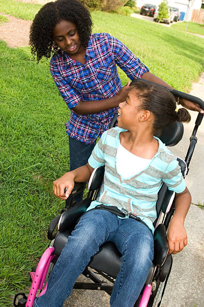 istock Tween helping her friend in wheelchair 157438555