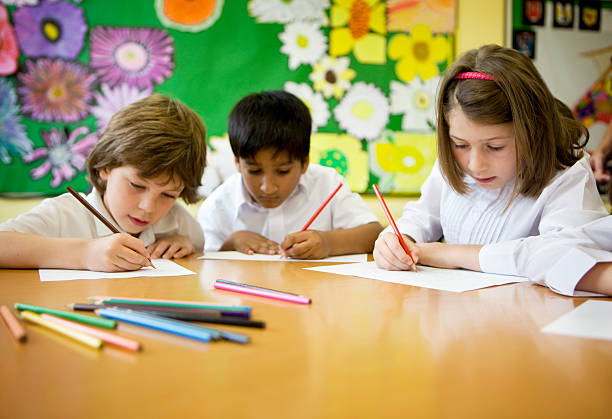 primary school: pupils learning to write in the classroom  colouring stock pictures, royalty-free photos & images