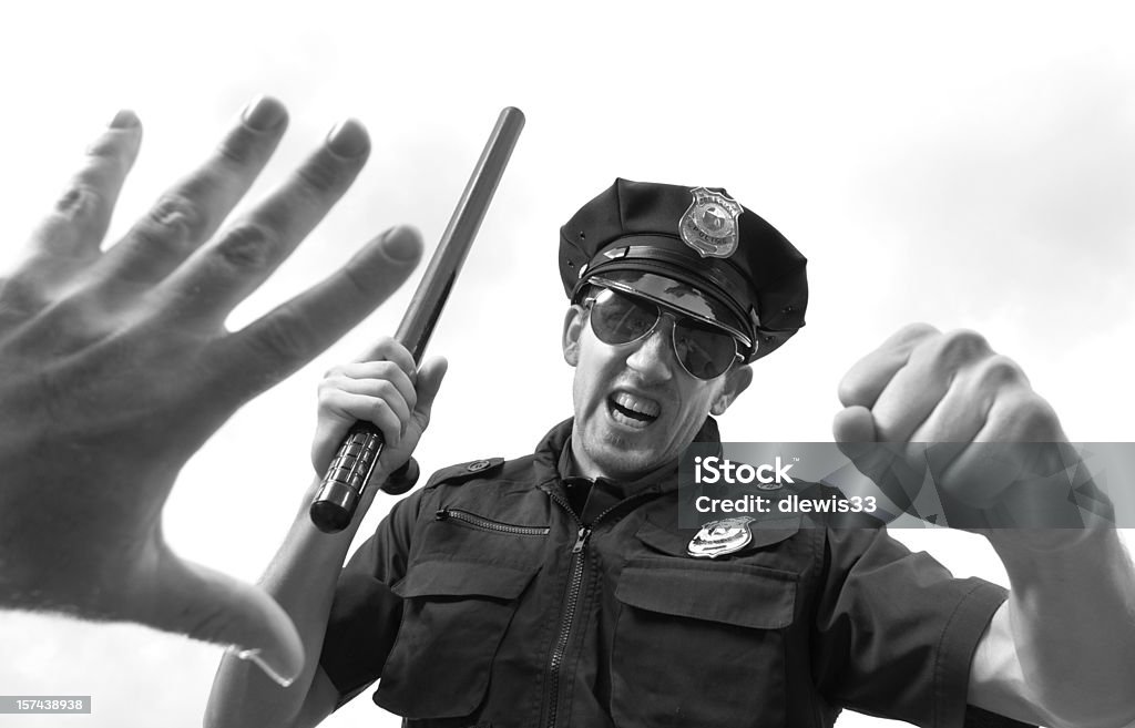 Police Aggression Police officer threatening a man on the ground. Police Force Stock Photo