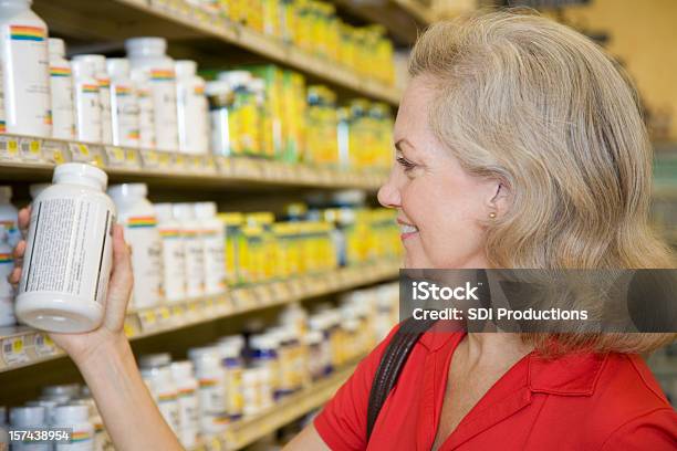 Senior Adulto Mulher A Ler O Conteúdo Da Vitamina Frasco - Fotografias de stock e mais imagens de Vitamina - Descrição