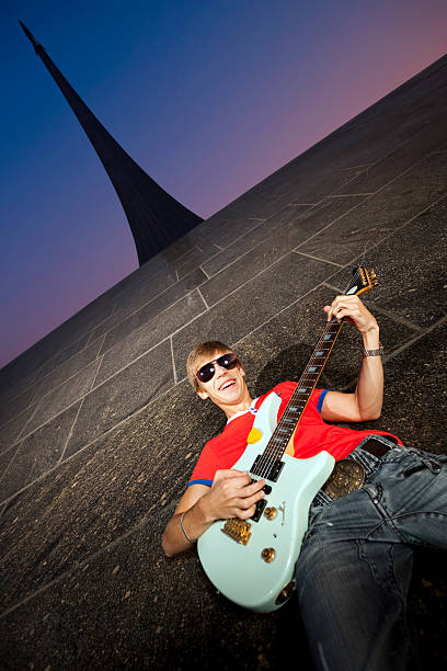 istock Laughing Young Musician Playing Guitar at Space Monument 157439052