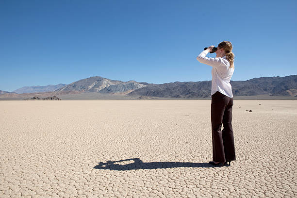 istock Business woman in desert looking through binioculars 157439274