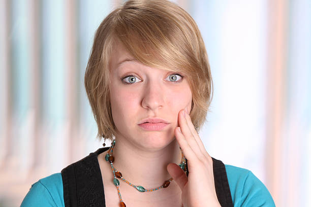 giovane donna fare gesti mal di denti - isolated on white brown white anxiety foto e immagini stock