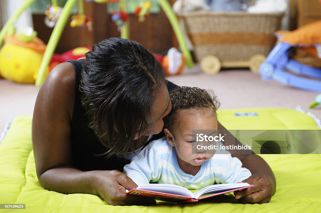 Storytime on the Playmat with Mother and Baby Storytime on the playmat with mother and baby in an indoor setting Baby - Human Age Stock Photo