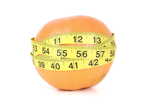 Grapefruit wrapped up with measuring tape.