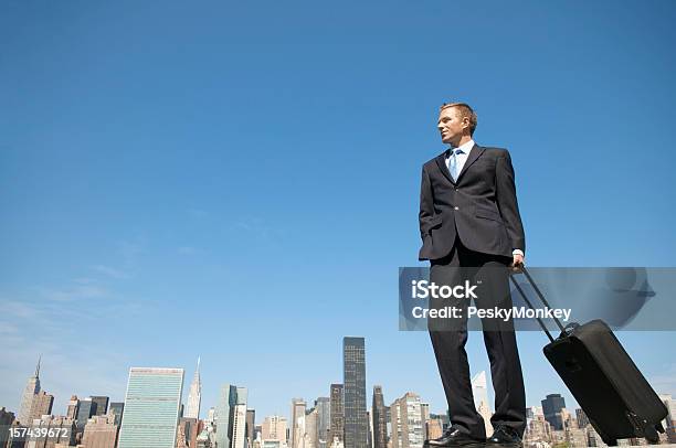 Giovani Uomo Daffari In Piedi Con La Valigia Sopra La Skyline Della Città - Fotografie stock e altre immagini di Abbigliamento elegante