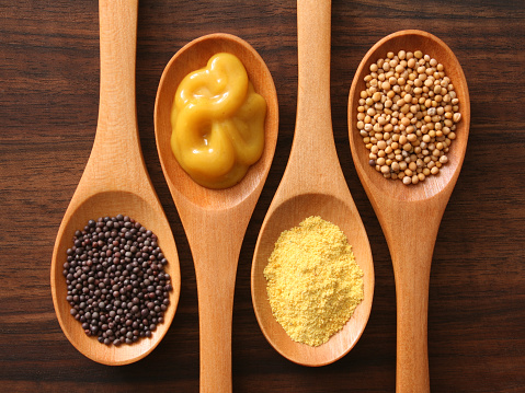 Four spoons with varieties of mustard