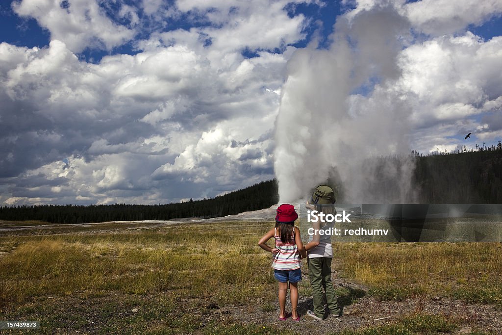 Deux jeunes filles Regardez Geyser Old Faithful est Entrer en éruption - Photo de Parc National de Yellowstone libre de droits