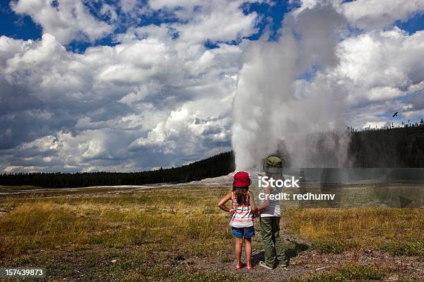 Photo libre de droit de Deux Jeunes Filles Regardez Geyser Old Faithful Est Entrer En Éruption banque d'images et plus d'images libres de droit de Parc National de Yellowstone