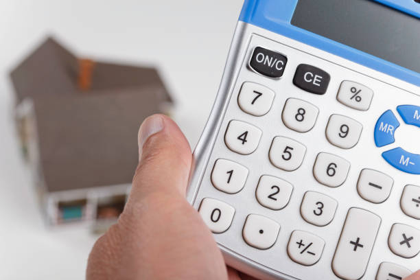 Holding calculator for house mortgage or home loan math Calculator to figure out your house mortgage for sale sign information sign information symbol stock pictures, royalty-free photos & images