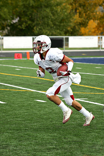 jogador de futebol com a bola durante corridas de fundo chato retorno - football player american football sport determination imagens e fotografias de stock