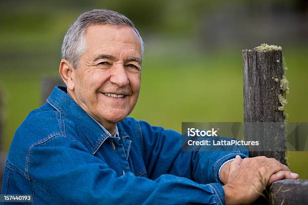 Foto de Sênior Homem Sorridente Com Os Braços Na Cerca De Madeira e mais fotos de stock de 60 Anos
