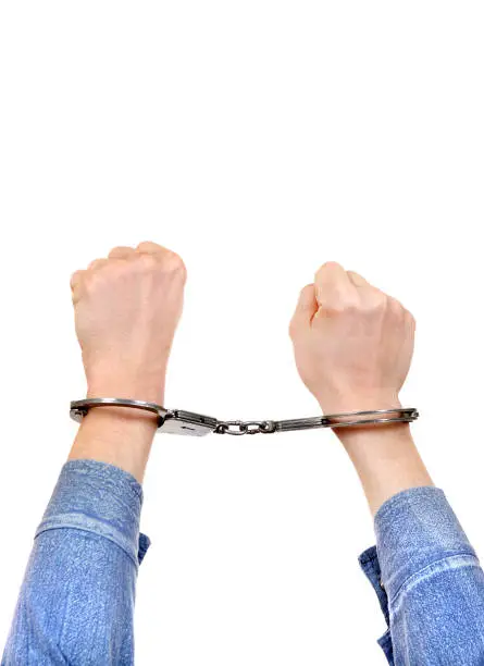 Handcuffs on the Hands Isolated on the White Background closeup