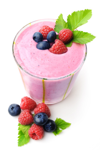 Blueberry and raspberry smoothie with garnish. On white, copy space.