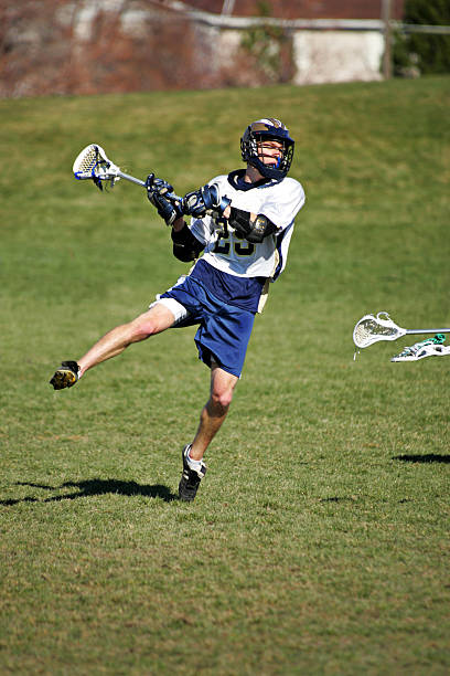 Male Lacrosse Player Jumps into a Shot on Goal stock photo