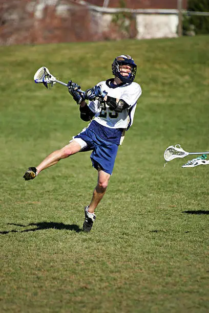 A lacrosse player winds up for airborn shot.  