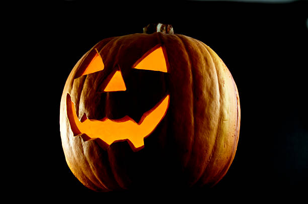 Jack O' Lantern at Night A Jack O' Lantern in the dark of night with copy space on a black background. jack o lantern photos stock pictures, royalty-free photos & images