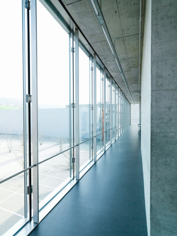 Modern Architecture. Corridor with large glass facade in office building together with concrete walls and concrete roof.