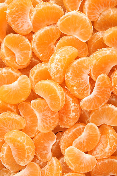 Tangerine wedges background Top view of fresh tangerine wedges tangerine stock pictures, royalty-free photos & images