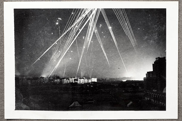 Air Raid On Alexandria Egypt Rare black and white wartime photograph of a night air raid on Alexandria, Egypt in 1943. Anti-aircraft tracer bullets light up the sky and a series of explosions illuminate the right hand horizon. Dust and scratches reflect age and condition of original image. bomb photos stock pictures, royalty-free photos & images