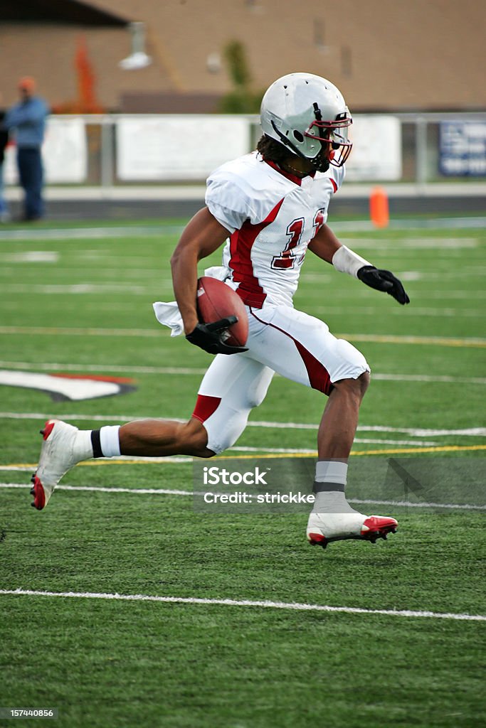 American Footbal Player in Flying Sprint after Pass Reception Wide receiver gains after catch. American Football - Ball Stock Photo