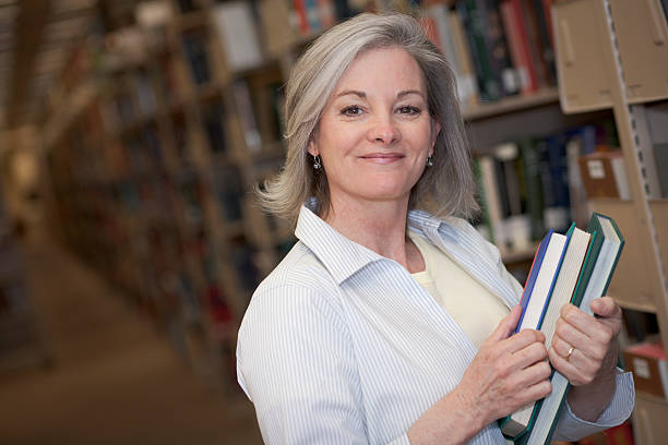 femme à la bibliothèque série (xxl - adult student women mature adult library photos et images de collection