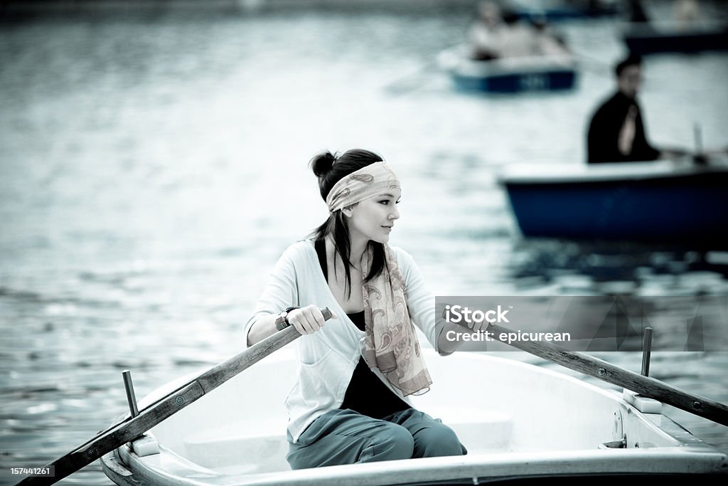 Giovane donna da sola in una barca a remi - Foto stock royalty-free di Acqua