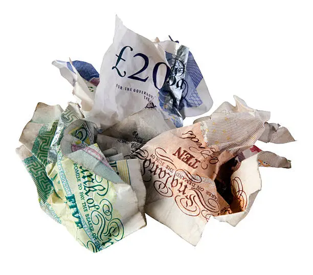Scrunched up British bank notes - £5, £10 and £20. Isolated on white.